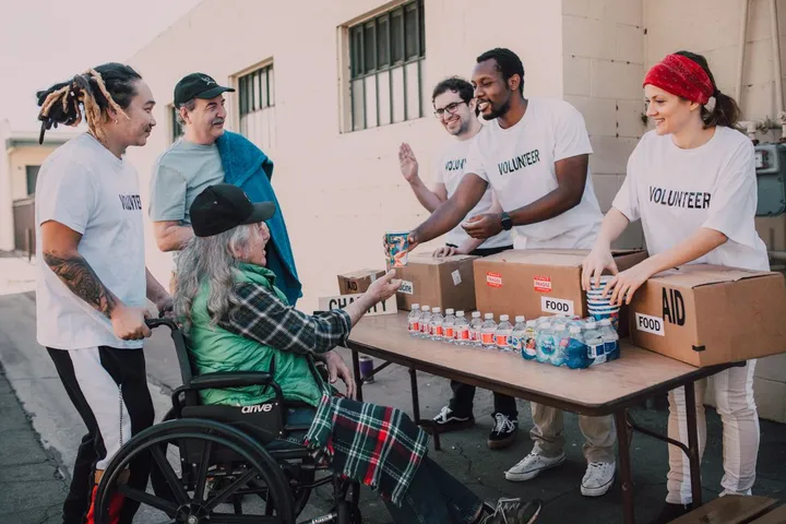 Volunteers handing supplies to people at an outdoor stand