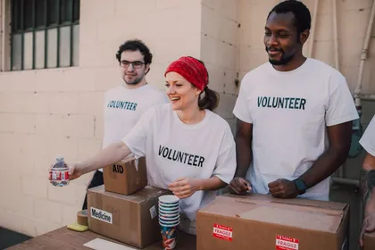 Volunteers in white shirts packing aid boxes