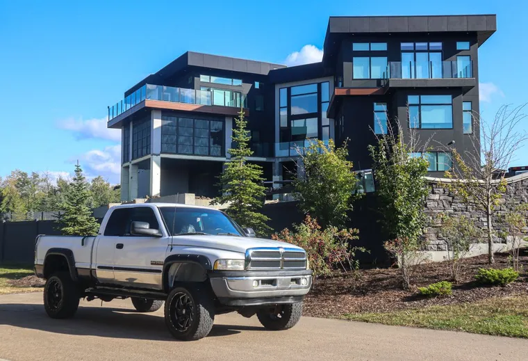 Silver pickup truck parked outside a modern house