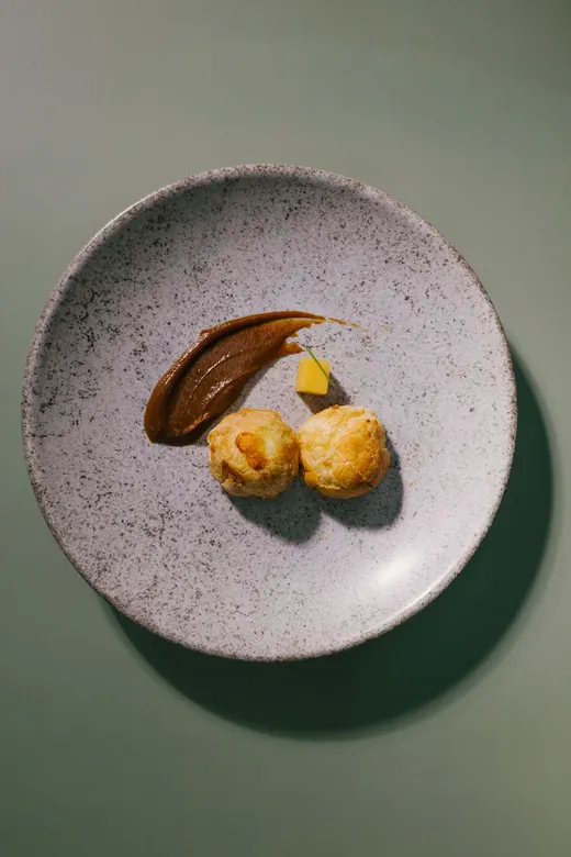 Dessert plated with sauce on a speckled ceramic plate