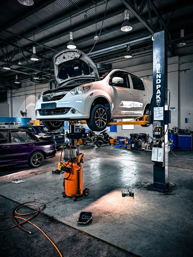 Car raised on a lift in a well-equipped workshop